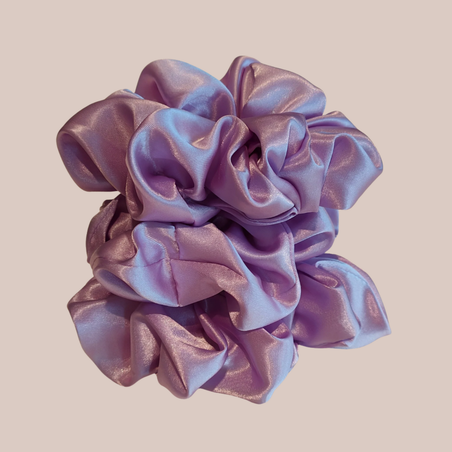 A photo of 3 lavender silk scrunchies stacked up on top of each other