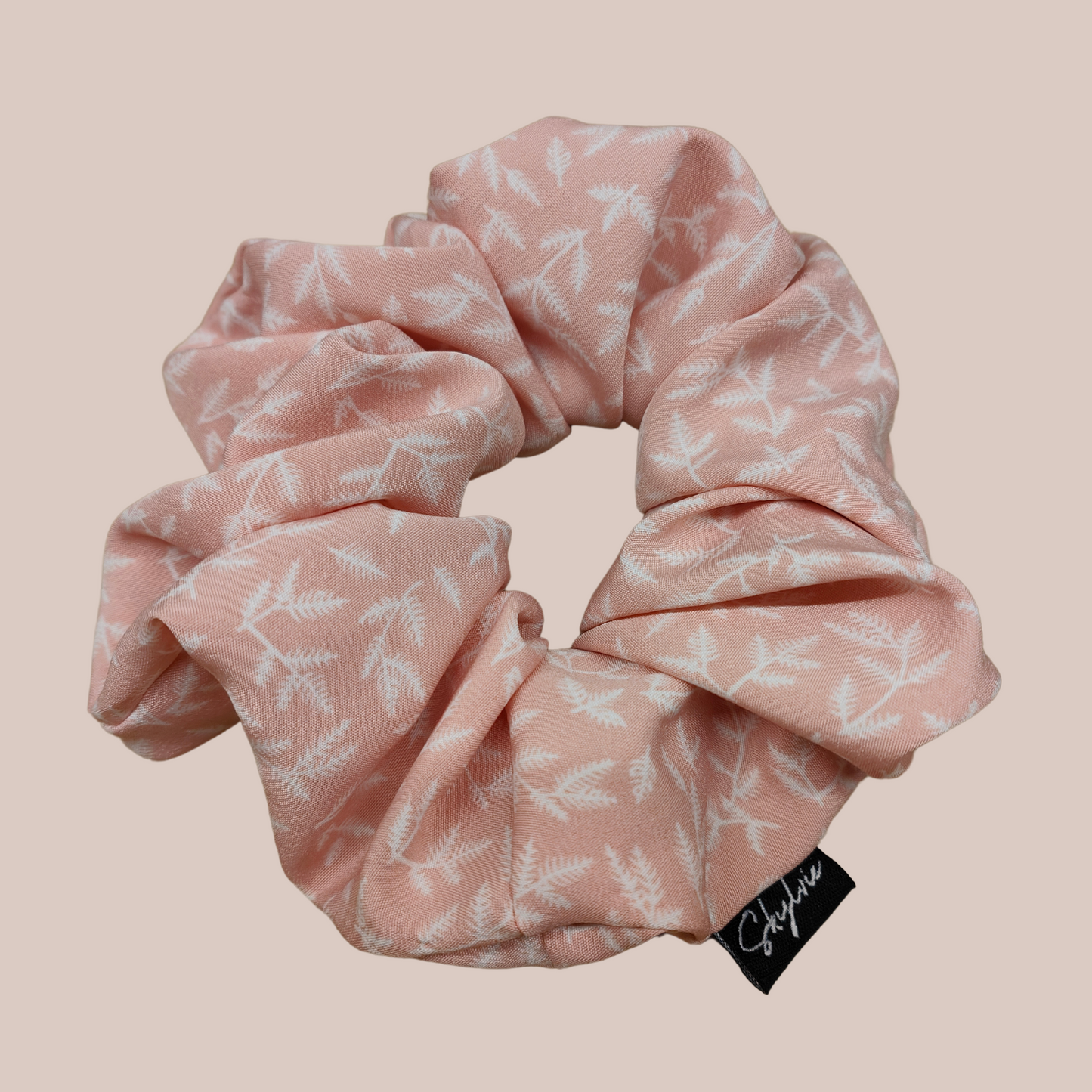 Sheryl Scrunchie, a pink scrunchie with tropical white leaves